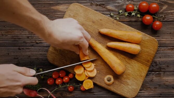 Cutting Carrots on a wooden board
